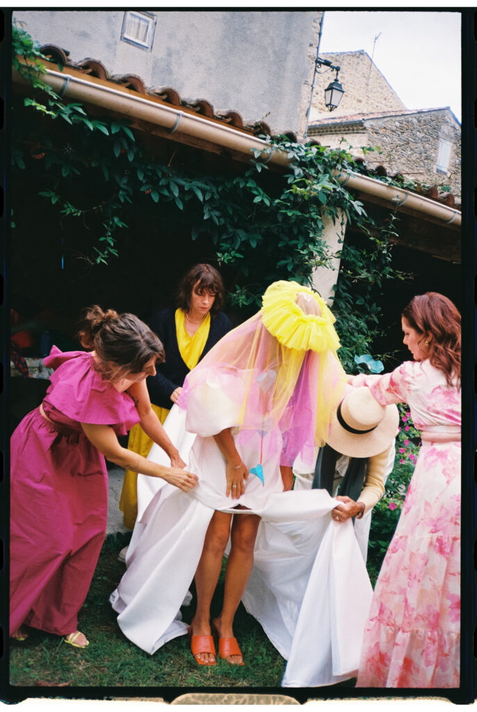 Bride putting on her dress with her maids